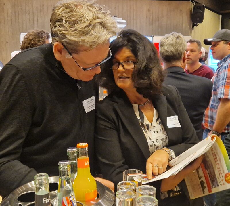 Veranstaltungsmanagerin Irene Parting zeigt Frank Vaaßen die Nachberichterstattung vom Ortsfest im Merzenicher Amtsblatt.