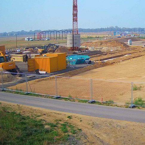 Bauplatz mit Containern, geglätteter Grundstücksfläche und Kran